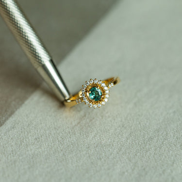 0.33ct natural alexandrite halo ring in 18k yellow gold with diamond accents.